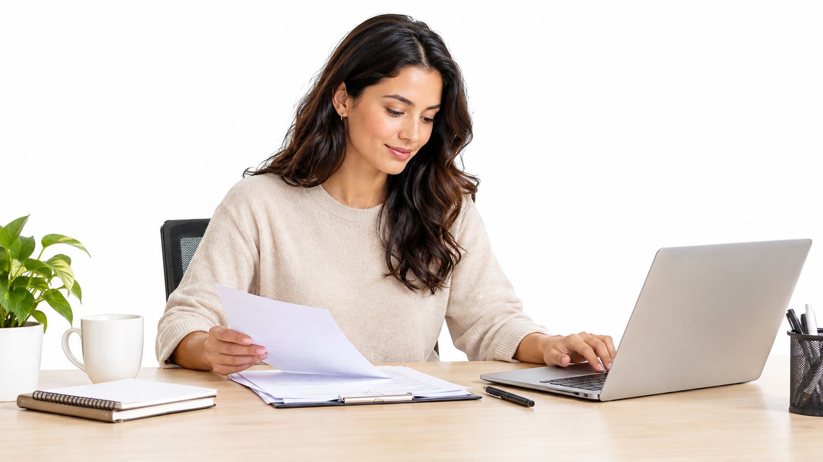 A professional woman working at a wooden desk with a laptop, documents, and office supplies.